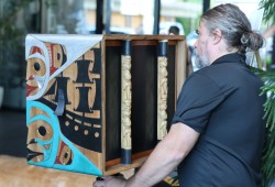 On the side of the bentwood box pinhole camera are ships, one representing Captain Cook and the other Spaniards.