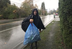 Richard Anthony Dick carries cans to cash in at a bottle depot, money he hopes will pay for his ferry ticket to the mainland so he can move into a recovery home. (Eric Plummer photo)