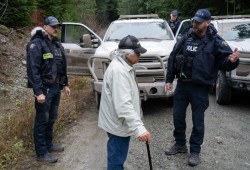 RCMP officers speak to Pacheedaht elder Bill Jones, who has acted as a spokesperson for those in support of the blockades.