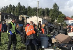 Cleanup crew at work, gathering automotive debris in the village.