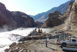 Crews drill into a boulder in preparation for blasting. (DFO photo)