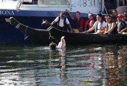 Food is offered to Wesley Frank and his paddlers at Canal Beach, as they await permission to go to shore. (Eric Plummer photo)