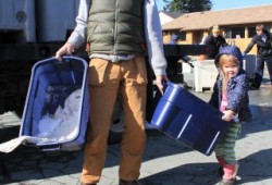 Corey Anderson and his three-year-old daughter Annika carry their halibut from the Tseshaht First Nation's distribution to its members.