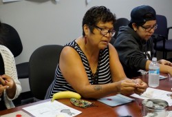 Cindy Keitlah learns to make a red dress pin from volunteers with the Lil' Red Dress Project on Aug. 30 at the Teechuktl Mental Health office in Port Alberni.