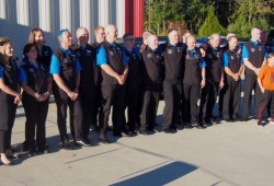 Tour de Rock cyclists and support crew assemble for a photo at Alberni Athletic Hall.