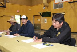 Pacheedaht’s Hereditary Chief Frank Queesto Jones (far left), Huu-ay-aht Tayii Ḥaw̓ił ƛiišin (Derek Peters) and Ditidaht Chabut Satiixub (Hereditary Chief Paul Tate) sign the Hišuk ma c̕awak Declaration at the Ditidaht Community School in Nitinaht Lake on June 4, 2021. The declaration pledged that the nations would take back authority over their territories. (Eric Plummer photo)