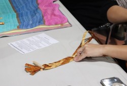 Theresa Burnip weaves a cedar headband for Jordan Burnip. 