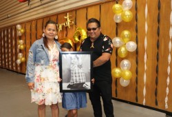 Diane and Wally Thomas hold a portrait of their son, the late Patrick Thomas. 