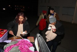 Jacquie Dennis hands out food, coffee, clothes and blankets to people behind Port Alberni’s Safe Injection Site on Nov. 8. Dennis conducted fundraising and travelled from Anacla to donate the supplies to those in need. This November front-line workers are observing that the suddenly cold temperatures are forcing some people to seek warm, dry places to use illicit drugs alone. (Eric Plummer photo) 