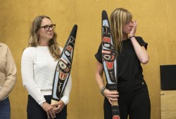Sarah Reid (left) and Kate Drexler are gifted paddles after the announcement of the new funding for a bighouse in Maaqtusiis Secondary on Flores Island, British Columbia, on August 10, 2022.