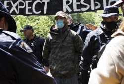 Gabriel Ostapchuk is arrested for refusing to comply with a media containment zone established by the RCMP at the Caycuse old-growth logging blockade, near Port Renfrew, on May 19, 2021. (Melissa Renwick photo) 