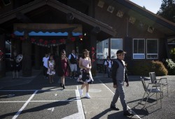 Sheldon Sam (right) leads his classmates as they walk from the Haahuupayak Elementary School to their seats outdoors during their Grade 7 graduation ceremony.