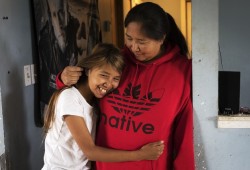 Norah Jack, 11, hugs her mother, Elizabeth, inside their home in Kyuquot, on August 13, 2020. 