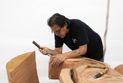 Patrick Amos helps to carve a totem pole at the Tofino Botanical Gardens, on July 9, 2021.