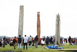 The new totem pole stands in between the two existing totem poles, in Opitsaht, on Meares Island, on July 1, 2022.