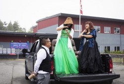 Steve Howard watches his daughter Roshelle Bob (centre) and friend, Abigail Titian-Manson, dance in the trunk of his truck before their graduation procession begins, in Ucluelet, on Saturday, June 20.