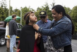 Erica Mack secures the shawl of Anna Patrick before getting her photos taken on her high school graduation day.