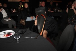 A raven steals items from tables at the Naaʔuu cultural event.