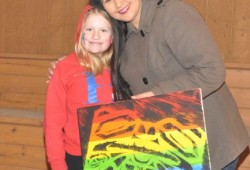 Taylor Blaise presents artist Connie Watts with a thank-you gift.