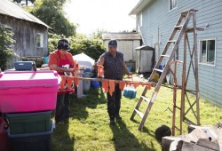 Marilyn and Frank Short hang salmon from beams that will be transported into their smokehouse, in Kyuquot, on August 12, 2020.