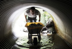 Kyle Adams, an environmental monitor with the Central Westcoast Forest Society, unloads gravel in the Mackenzie Creek culvert.