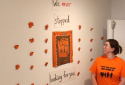 Ali Sawyer looks up at the display of beaded orange shirts at the Tofino Arts Council Hallway Gallery.