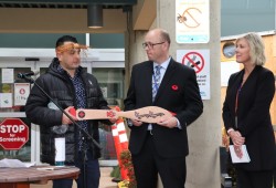 Tseshaht Chief Councillor Ken Watts gives a paddle to West Coast General Site Director Derek Keller, as Leanne Frechette, director of Clinical Service Delivery for central and north Vancouver Island's community hospitals, watches. 