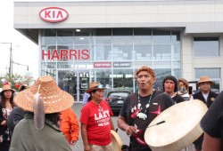 Pamela Webster's son Guy Louie Jr. drums in front of the Kia dealership in August. 