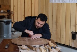 Artist Josh Watts shapes a piece of wood during the opening of the Next Generation Indigenous Art Show at the Naa’Waya’Sum Carving Studio.