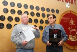 With the Wall of Fame behind them, ADSS Athletic Director Mike Roberts references the sporting legacy of Tom Watts.