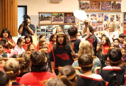 Students warm up their voices in the school lobby before the grand entry.