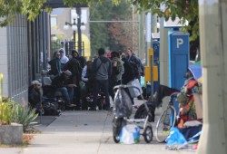 People congregate outside an overdose prevention site on Pandora Avenue in Victoria, one of three listed in the Vancouver Island city. (Eric Plummer photos)