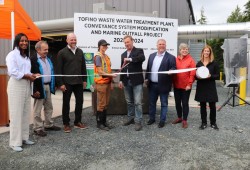 From left: Tofino CAO Nyla Attiana, TFN Tribal Administrator Jim Chisholm, Tofino Mayor Dan Law, Tofino’s Utility Operator Lead Christine Biegler, Tofino’s Manager of Infrastructure and Capital Projects Simon Kirkland, MP Gord Johns, MLA Josie Osborne and Tourism Tofino’s Board Chair Sabrina Donovan cut a ribbon of toilet paper on Aug. 22, 2024 to open a wastewater treatment plant. The facility ended Tofino’s decades-long practice of dumping raw sewage into the ocean, but brought a surge in utility rates.