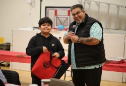 Coquitlam resident Trevyion Jack of Ehattesaht was the first to win a door prize, an embroidered blanket presented by NTC Vice-President Les Doiron.