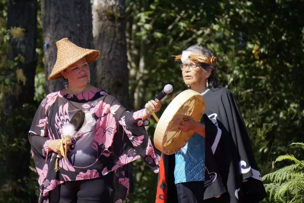Naomi Nicholson stands by as Nuu-chah-nulth elder sings a prayer song at Cims Fest on Aug. 6.