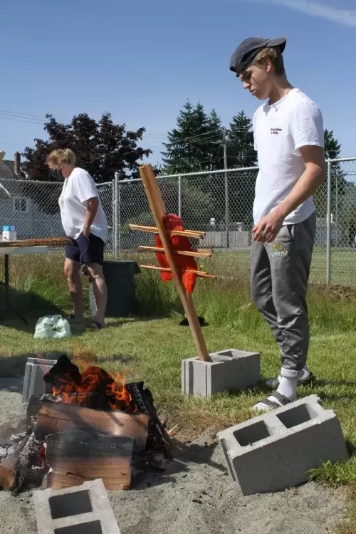 Grade 10 student Cameron Mar arranges the salmon for cooking.