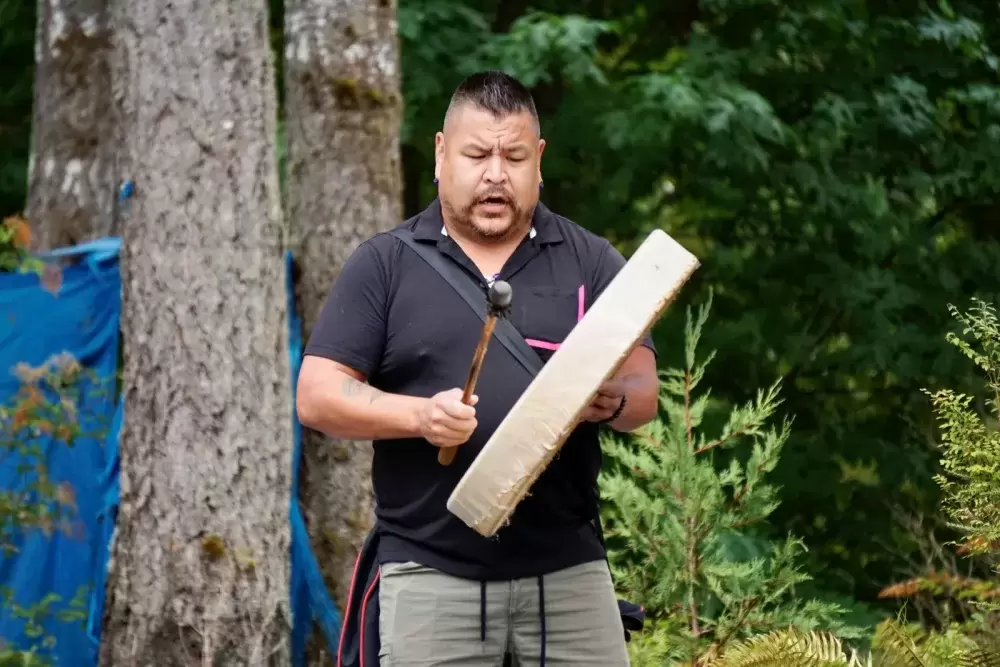 Ed Ross drums and sings an opening song during the Chims Guest House grand opening event on Aug. 7. 