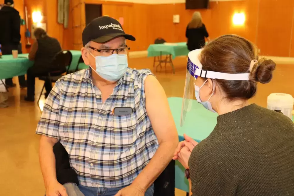 Hupacasath Councillor Jim Tatoosh receives his first COVID-19 shot, when NTC nurses brought Moderna doses to the House of Gathering on March 4, part of community immunization clinics being held across the province this month for on-reserve First Nations members. (Denise Titian photo) 