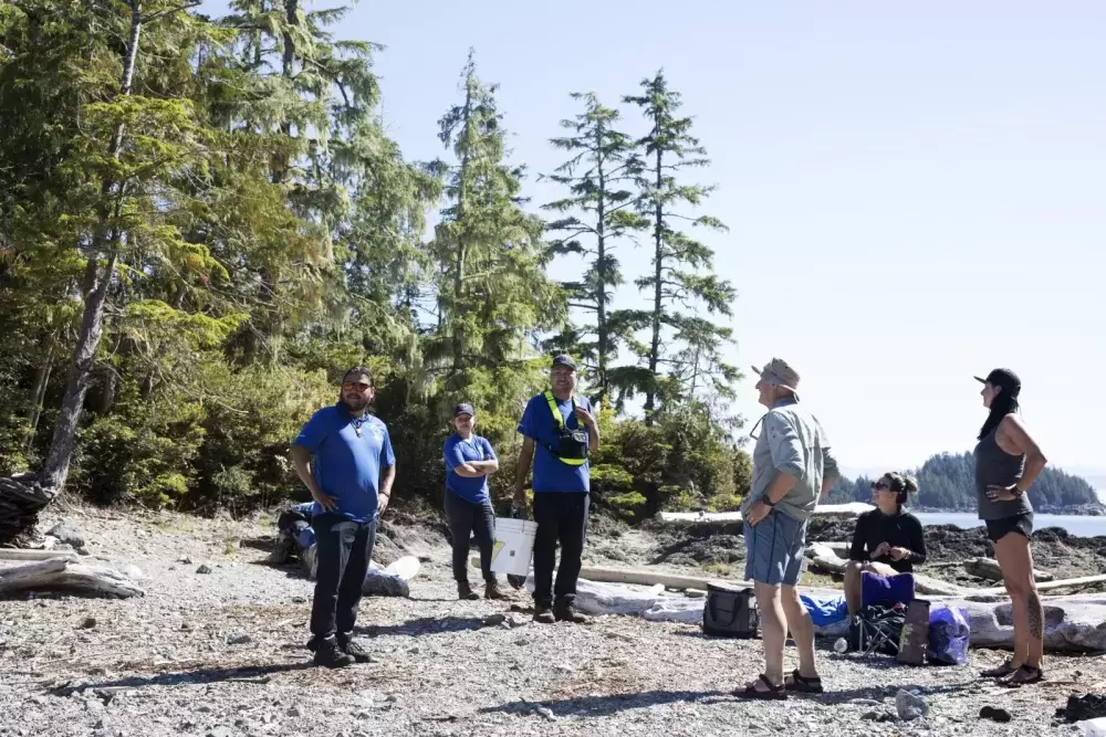 (From left to right) Shane Sieber, Memphis Dick and Hank Gus greet a group of kayakers on Gibraltar Island, in the Broken Group Islands, in Barkley Sound, on July 26, 2021.