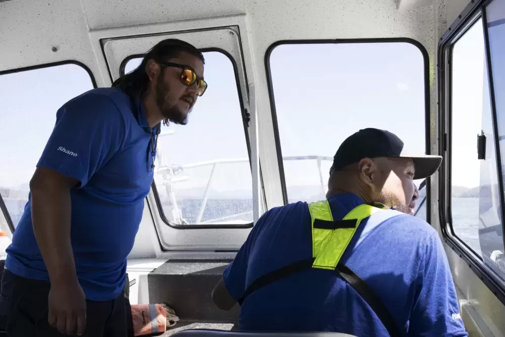 Shane Siebed (left) and Hank Gus look towards a group of kayakers to make sure they aren't paddling towards Benson Island, which is currently closed to visitors, in the Broken Group Islands, in Barkley Sound.