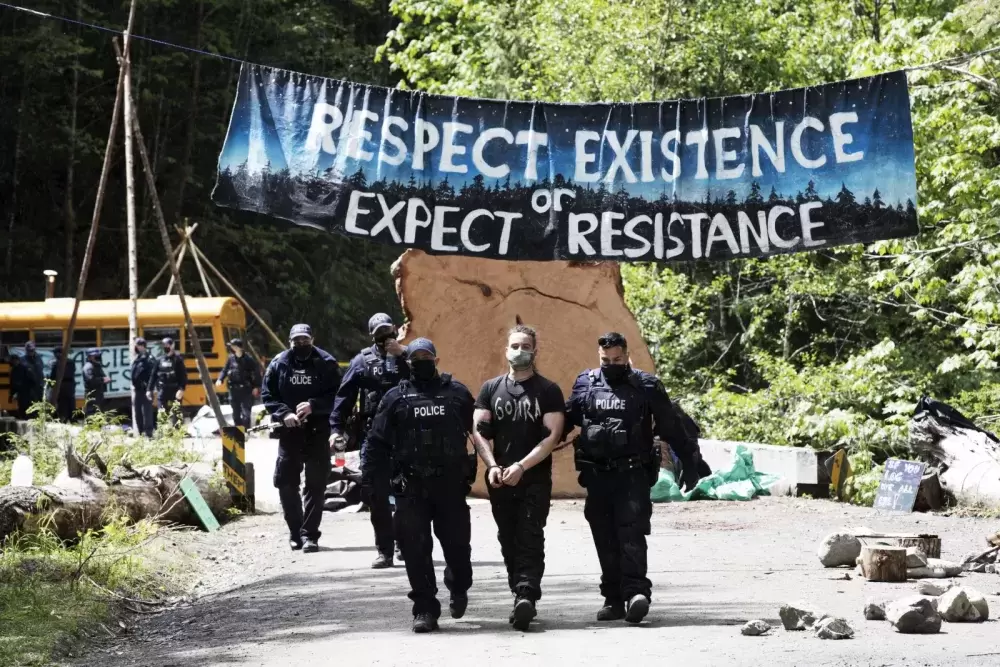 A protestor is arrested at the Caycuse old-growth logging blockade established by the Rainforest Flying Squad, near Port Renfrew, on May 19, 2021.