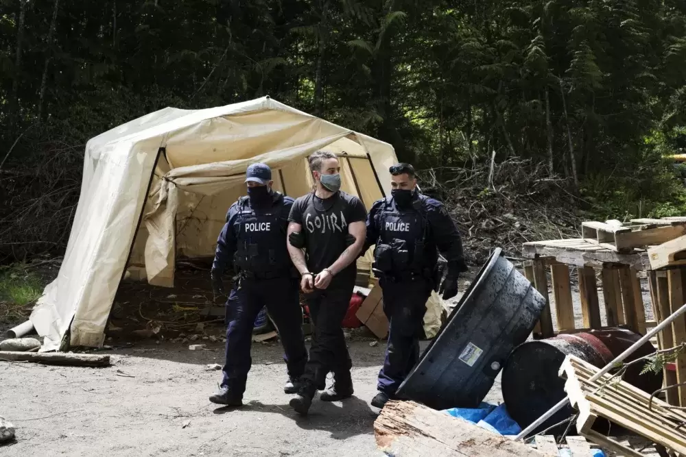 A protestor is arrested at the Caycuse old-growth logging blockade established by the Rainforest Flying Squad, near Port Renfrew, on May 19, 2021.