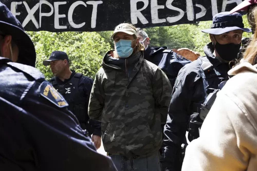 Gabriel Ostapchuk is arrested for refusing to comply with a media containment zone established by the RCMP at the Caycuse old-growth logging blockade, near Port Renfrew, on May 19, 2021.