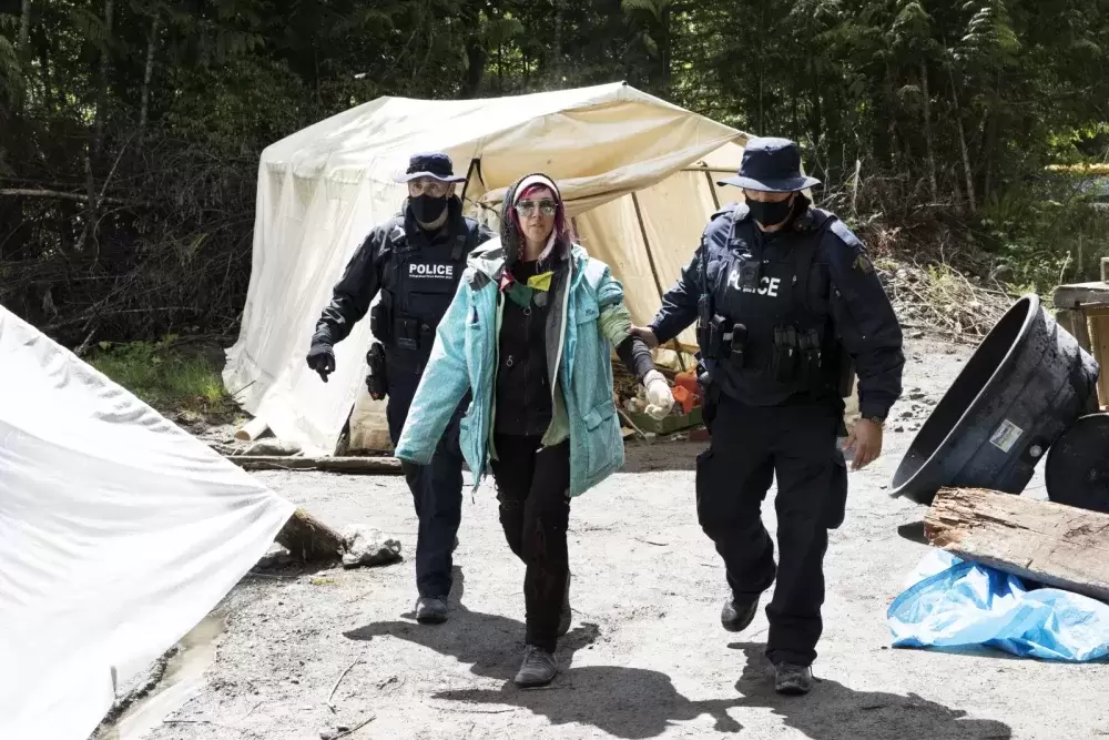 A protestor is arrested at the Caycuse old-growth logging blockade established by the Rainforest Flying Squad, near Port Renfrew, on May 19, 2021.