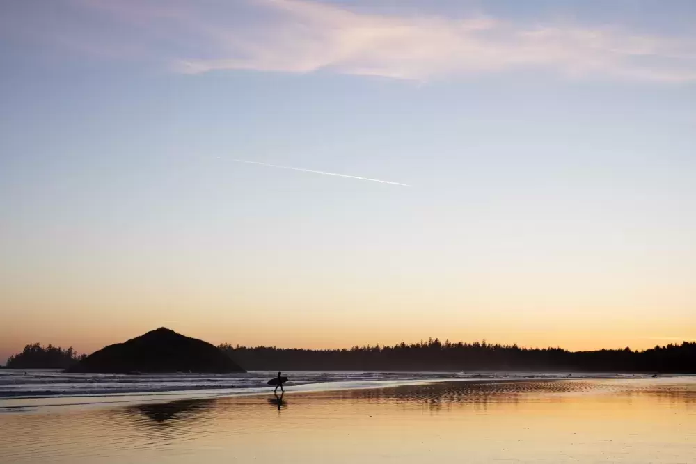 A surfer walks out of the ocean on Long Beach, near Tofino, on April 14, 2021. 