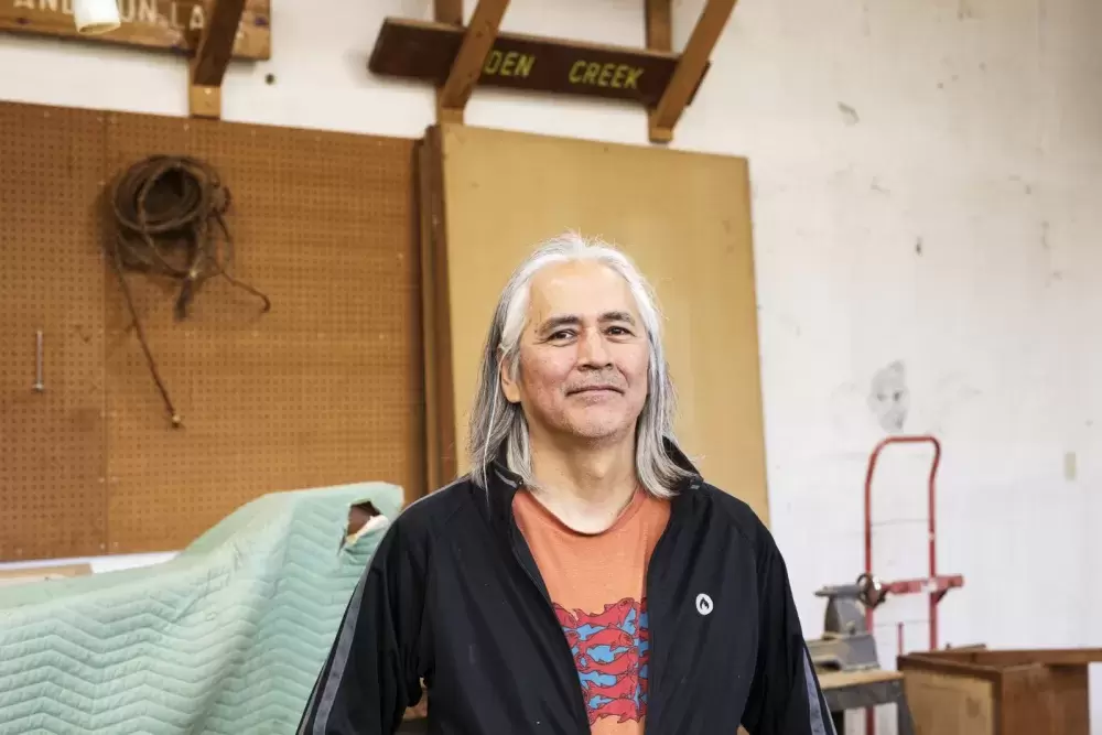 Rodney Sayers, a Nuu-chah-nulth artist from the Hupačasath First Nation, poses with a sample of his work in his Port Alberni studio on Oct. 4. (Melissa Renwick photo)