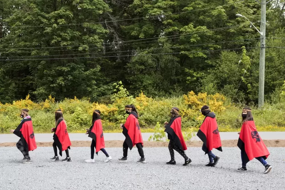 Grade 5/6 students at Haahuupayak Elementary School dance to a war song during the blessing of the school's new outdoor learning space, in Port Alberni, on June 10, 2021.