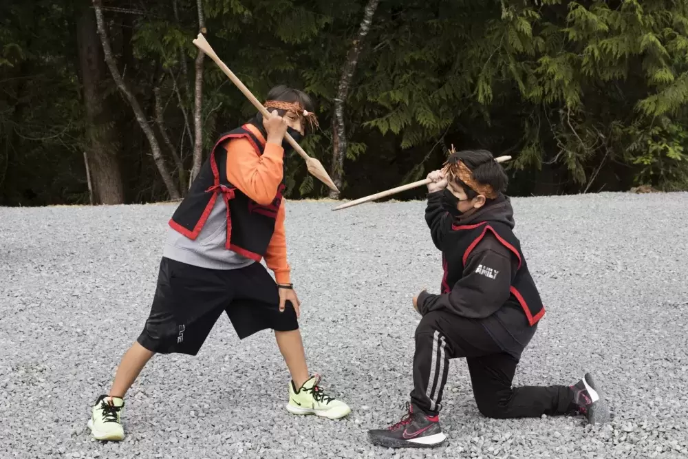 Grade 5/6 students at Haahuupayak Elementary School dance to a war song during the blessing of the school's new outdoor learning space, in Port Alberni, on June 10, 2021.