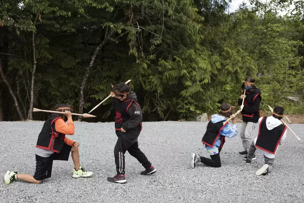 Grade 5/6 students at Haahuupayak Elementary School dance to a war song during the blessing of the school's new outdoor learning space, in Port Alberni, on June 10, 2021.