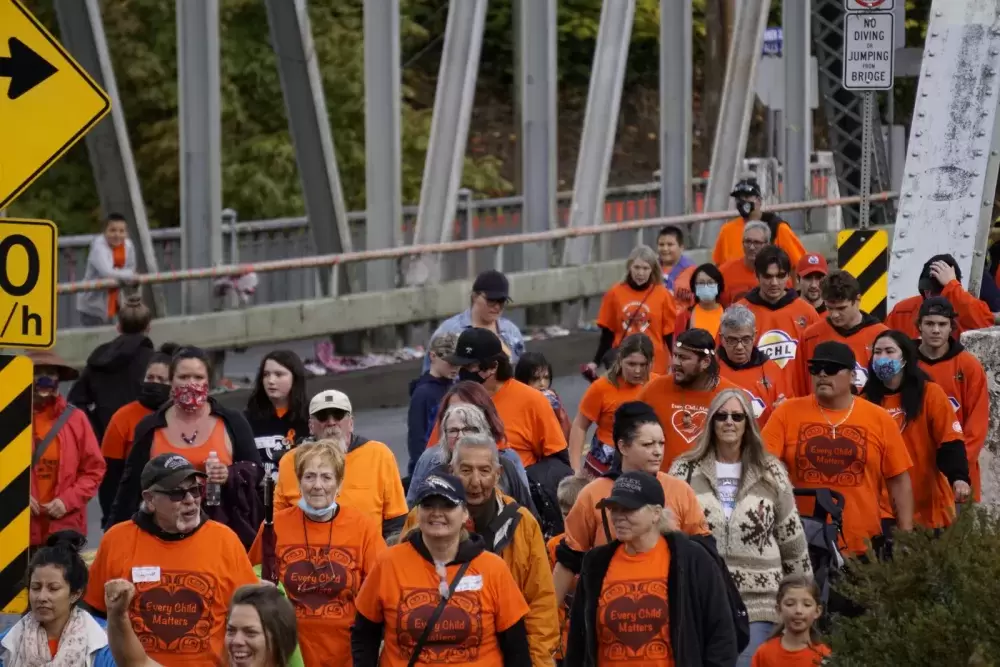 A crowd walks over the Orange Bridge to Maht Mahs gym on Sept. 30 to honour residential school survivors, and those who didn't make it home, for Orange Shirt Day and the first National Day for Truth and Reconciliation. Karly Blats photo